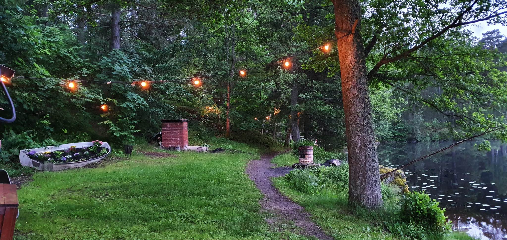 Evening path with string lights by the lake
